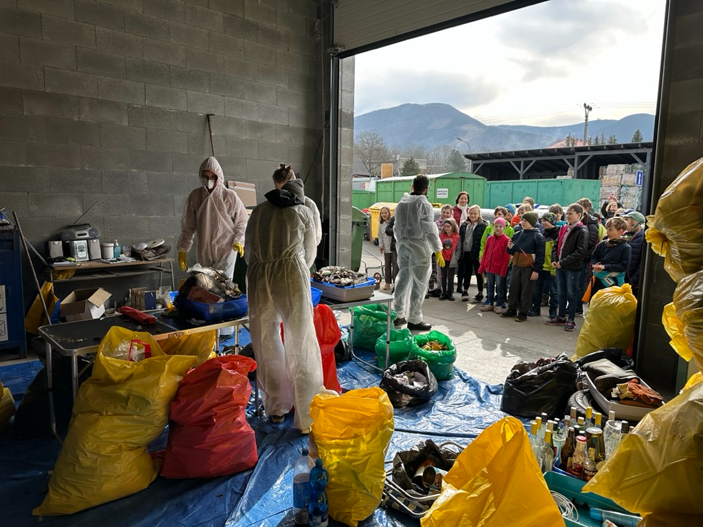 Foto výsledku jedné z odpadových analýz - směsný komunální odpad, který do popelnice patřil, je v pravém horním roku v černých pytlích (nerecyklovatelná směs) a červených pytlích (hygienické potřeby). Zbylý odpad bylo možné vytřídit.